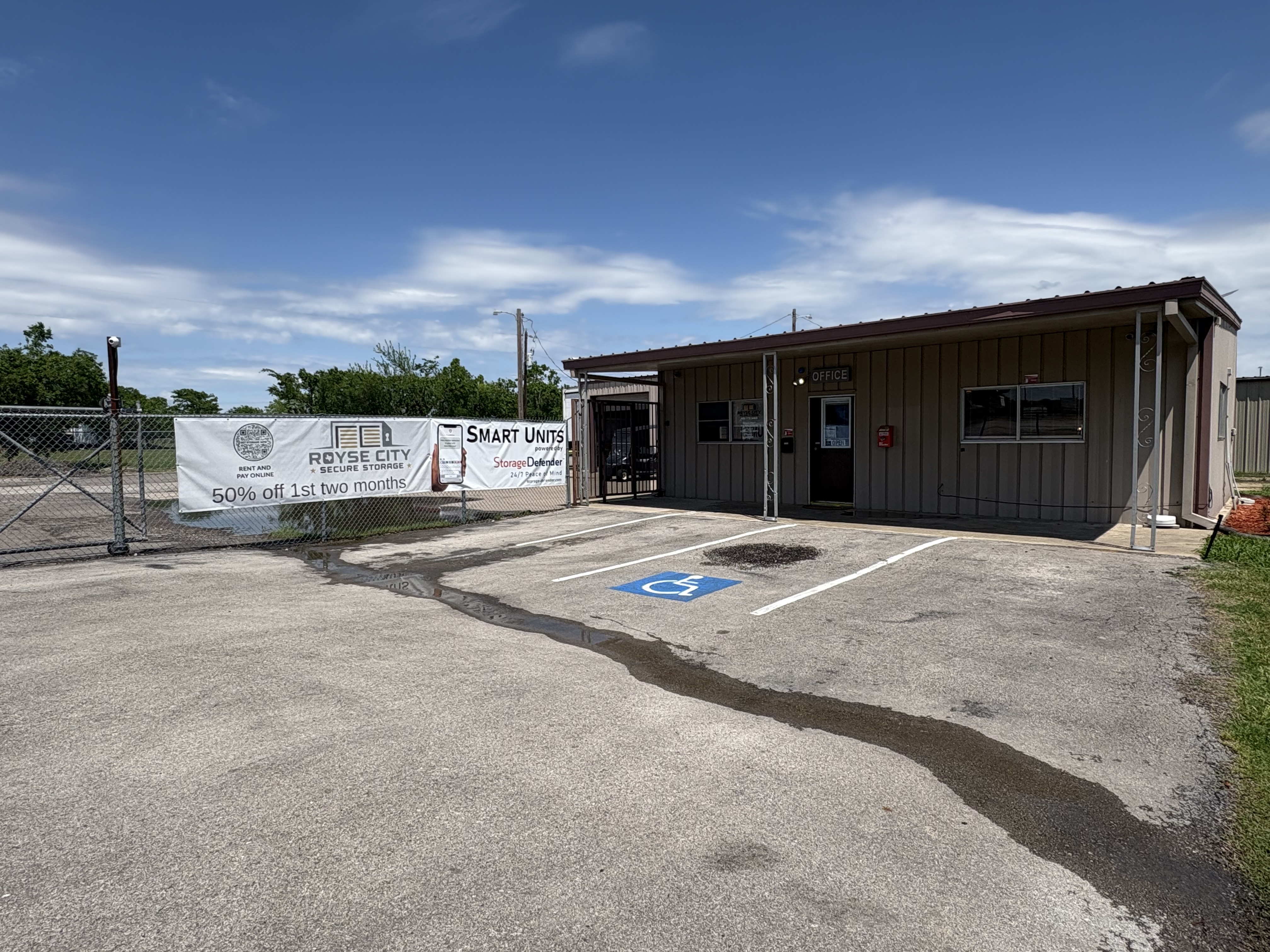 Front office of Royse City Secure Storage at 7451 FM 35, featuring promotional banner for 50% off first two months and accessible parking near Rockwall, TX.